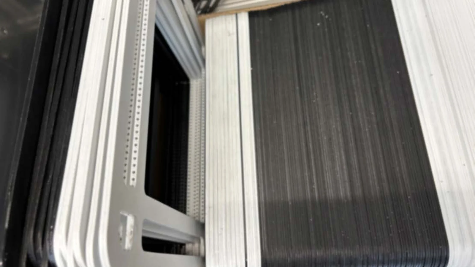 Stack of large-area electrolysis cell components with frames, prepared for stack assembly.
