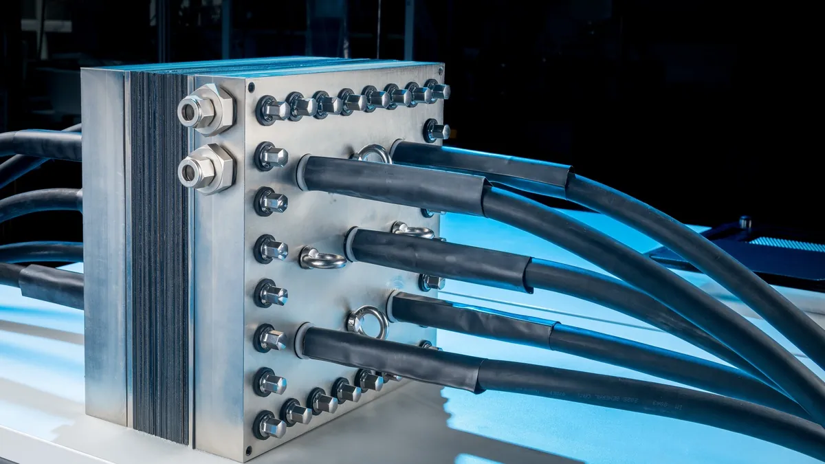 AEM electrolyser stack with end plate, bolted connections and heavy power cables on a test stand
