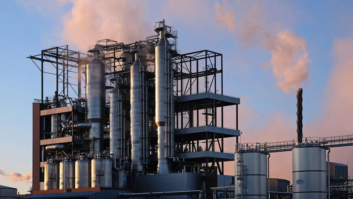 Chemical process plant with distillation columns and steel structures at dusk, representing an industrial hydrogen investment