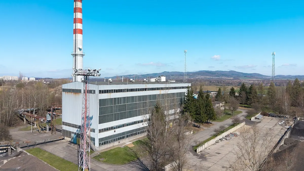 Industrial heating plant with boiler house and chimney supplying process and district heat