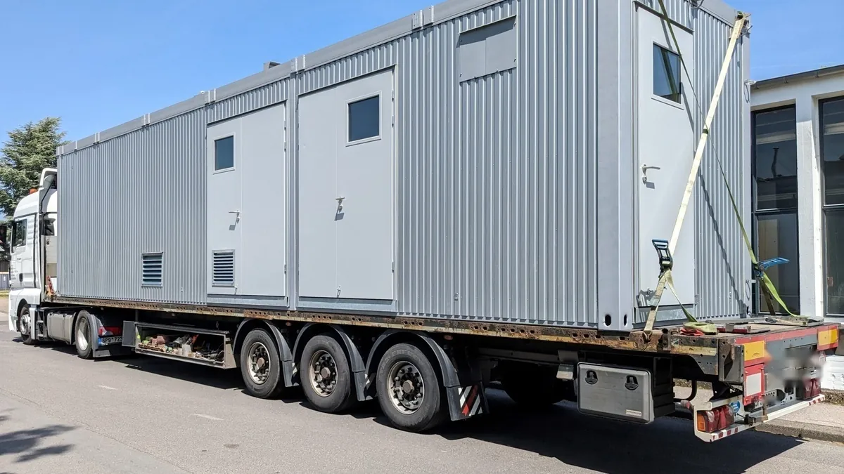 Electrolyser container loaded on a flatbed truck for transport to a funded demonstration project