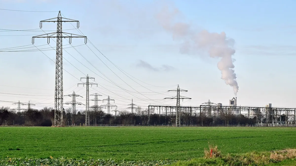 High-voltage substation and transmission lines in open countryside, where electrolysers can provide grid flexibility