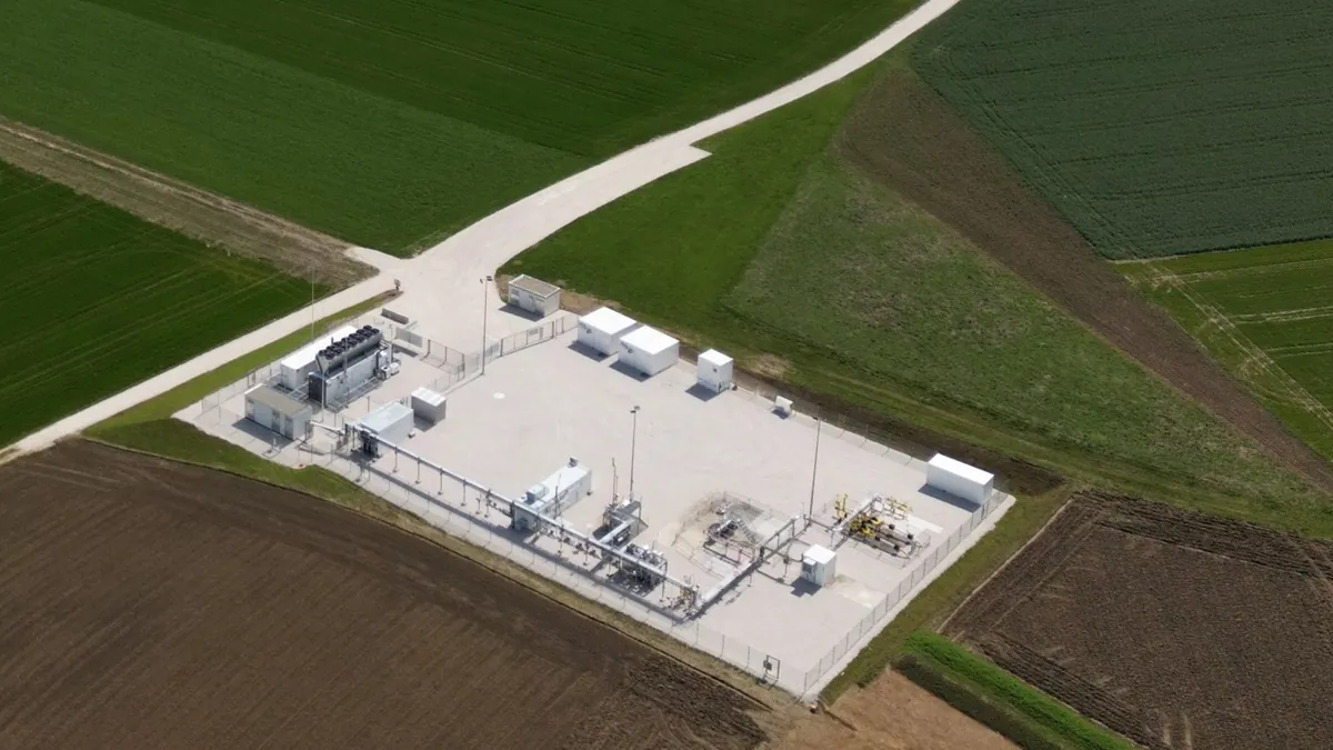 Aerial view of a compact hydrogen demonstration plant with process skids and containers in open farmland