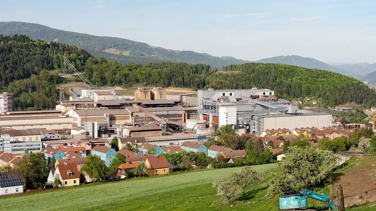 Integrated steelworks in a valley, with an electric arc furnace under construction as part of its decarbonisation
