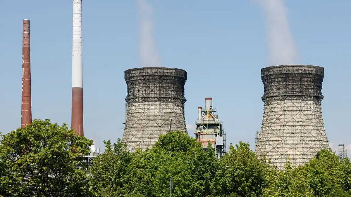 Oil refinery with cooling towers and process units, where RED III drives renewable hydrogen into transport fuels