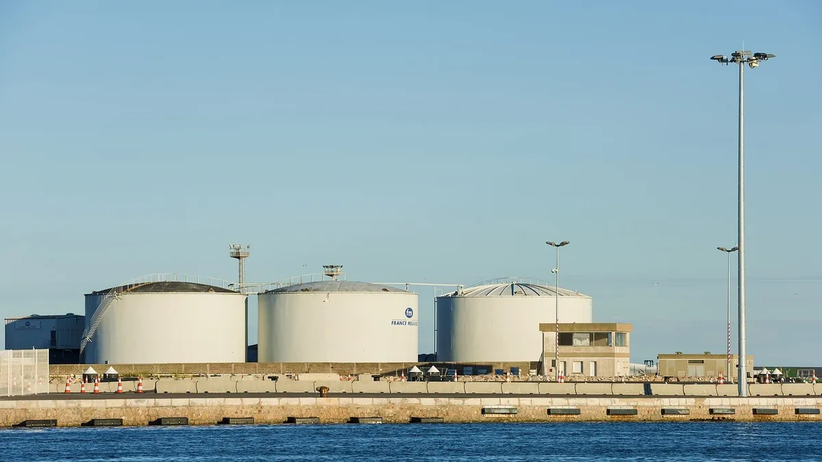 Large storage tanks at a port terminal quayside, the kind of infrastructure used for hydrogen and ammonia bunkering hubs