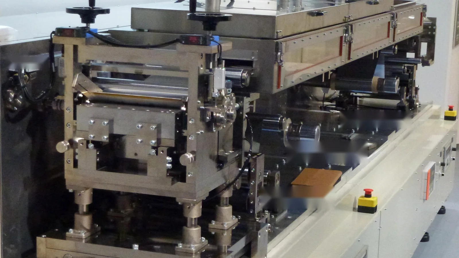 Roll-to-roll coating machine with a precision coating head, rollers and dryer section for continuous electrode production.